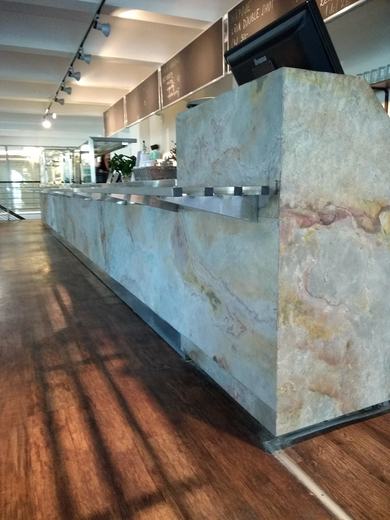 Výdejní pult v restauraci obložený kamennou dýhou